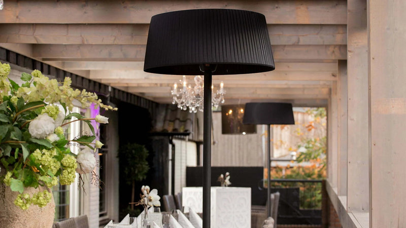 Artix Bright staande heater van Sunred onder een gezellige overkapping in de tuin